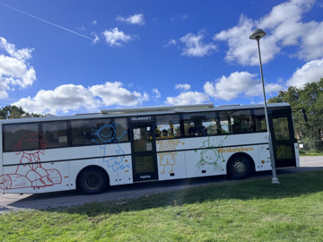 Foto på förskolebussens profil i soligt höstväder